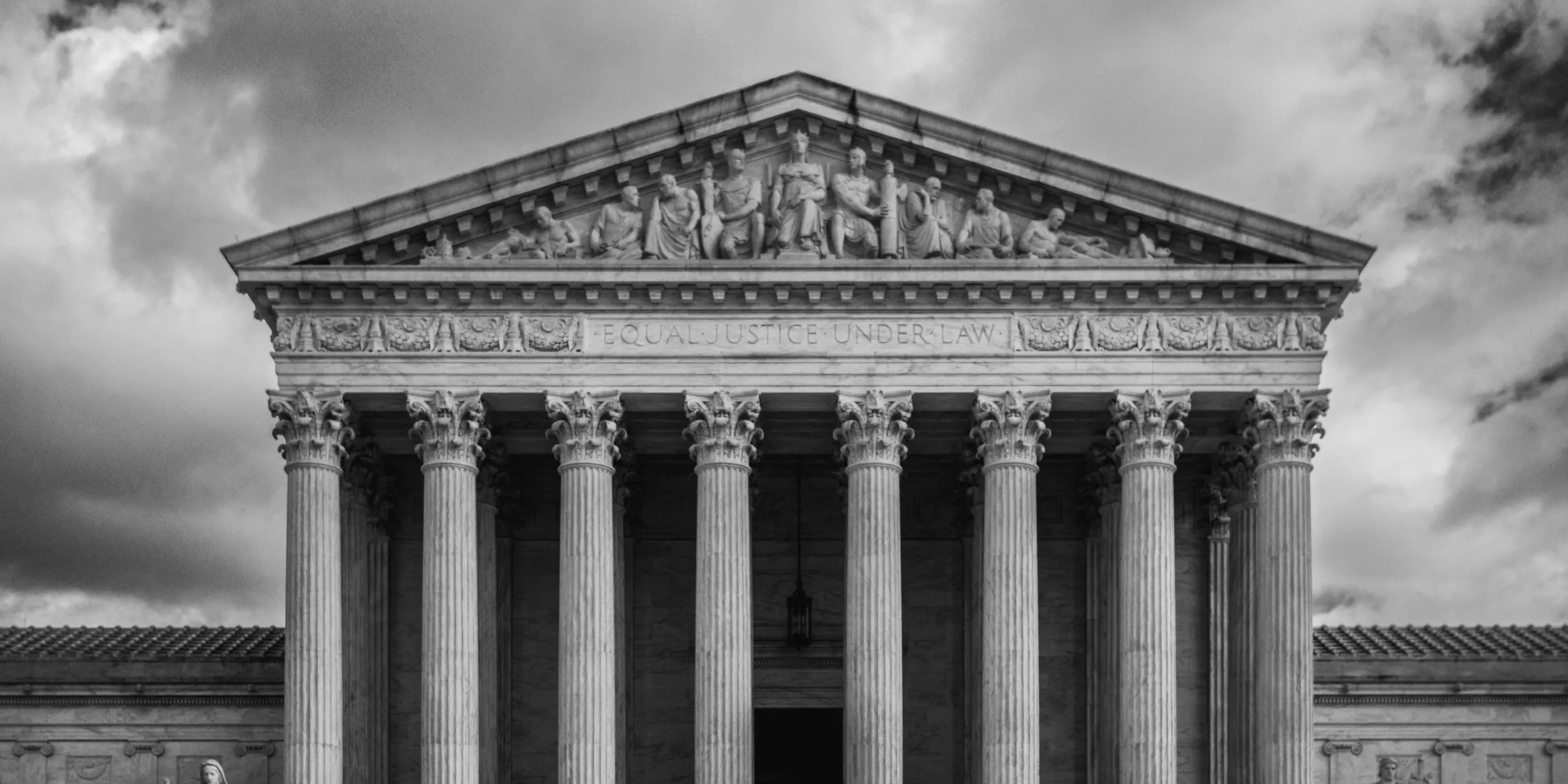 Black and white close-up of the United States Supreme Court building facade that says Equal Justice Under the Law